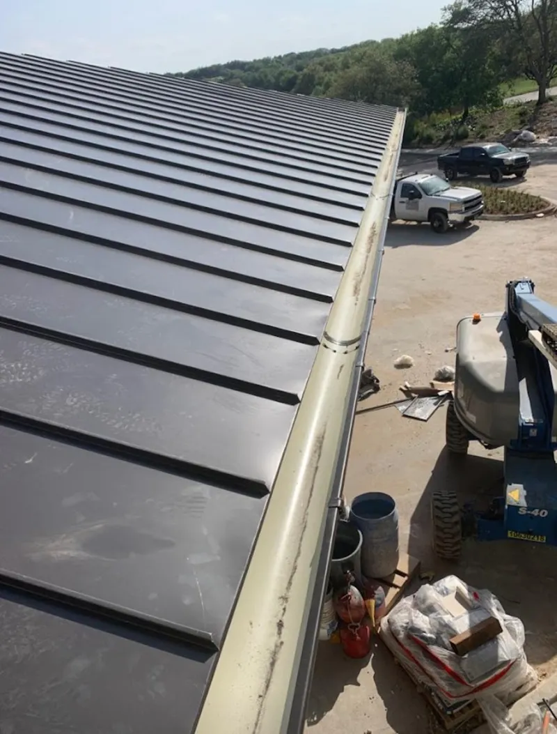 Standing seam panel and gutter detail on a metal roofing jobsite in Wasilla